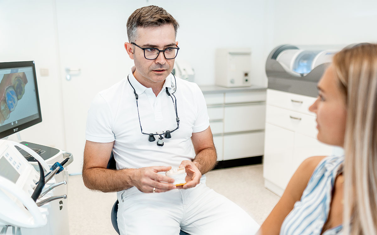 Daniel Krutsch, Zahnarzt in Darmstadt, erklärt einer Patientin am Rechner das Cerec-Verfahren.