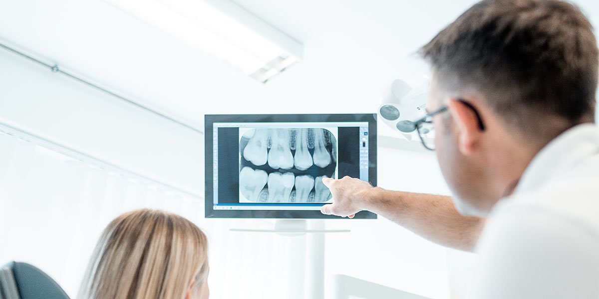 Zahnarzt Daniel Krutsch zeigt auf ein Röntgenbild. Ein Zahnimplantat soll in seiner Darmstädter Zahnarztpraxis gesetzt werden.