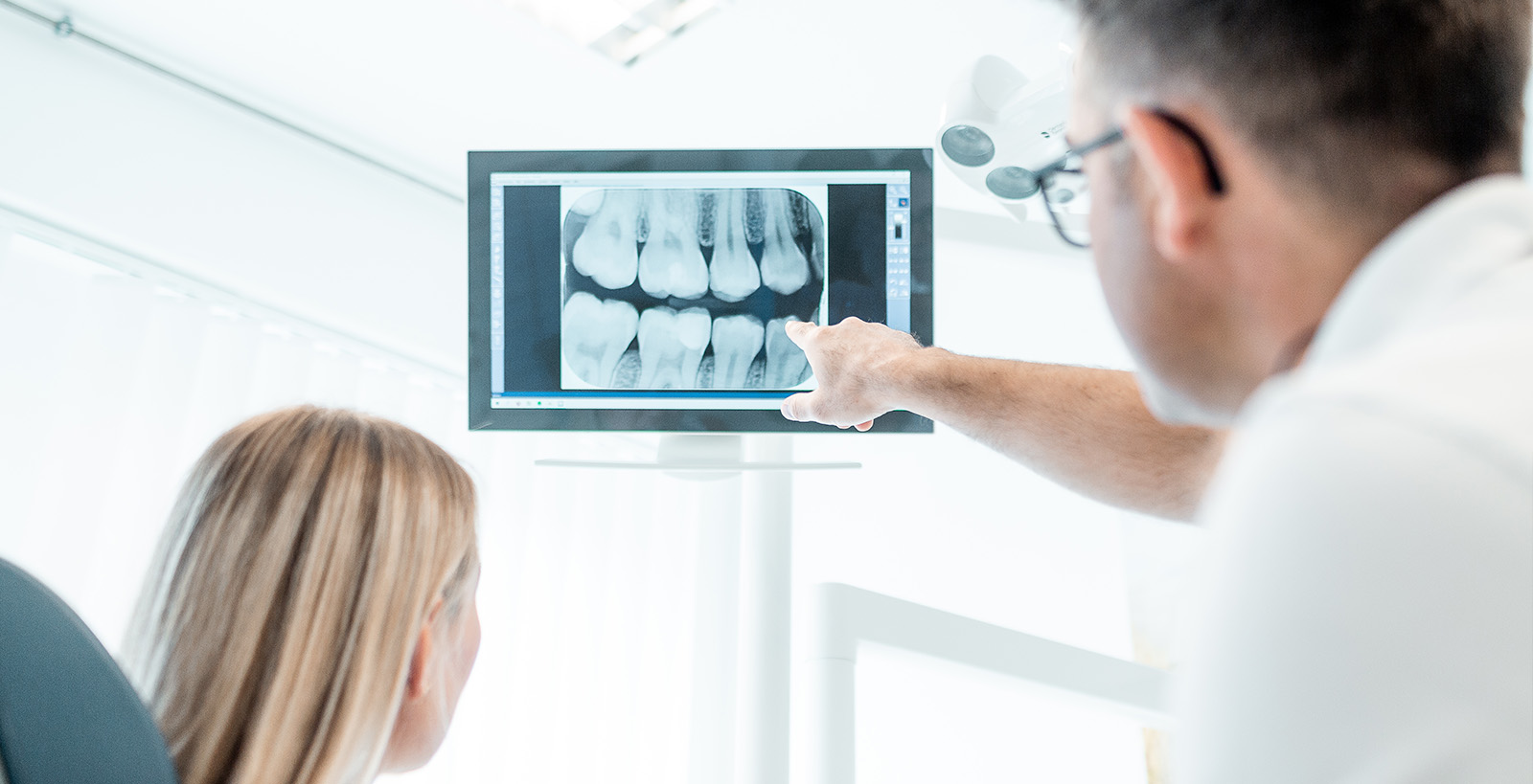 Daniel Krutsch aus Darmstadt zeigt einer Patienten auf dem Bildschirm warum eine Parodontitis-Behandlung ratsam ist.